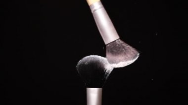 Siyah arkaplan Yavaş Hareket Konseptinde Renkli Toz ile Makyaj Fırçası
