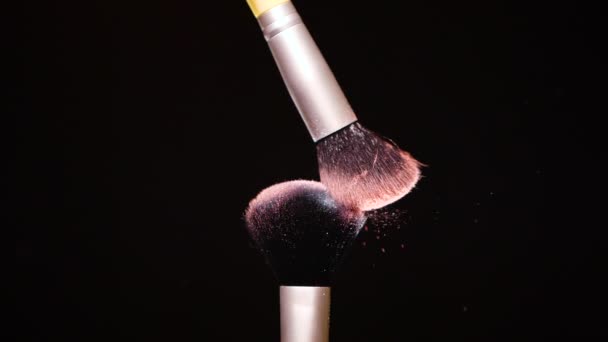 Make-up Pinsel mit farbigem rosa Puder auf schwarzem Hintergrund Slow Motion — Stockvideo