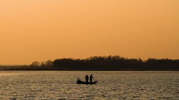 Barco con pescadores en el río al atardecer — Vídeo de stock