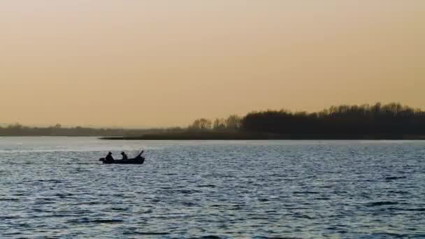 Båt med fiskare vid floden vid solnedgången — Stockvideo