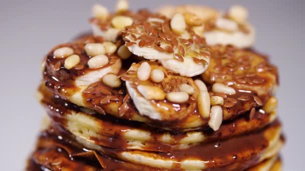 Crêpes au sirop de chocolat, noix et bananes. Une pile de flapjack entier. Petit déjeuner savoureux et aliments sains — Video