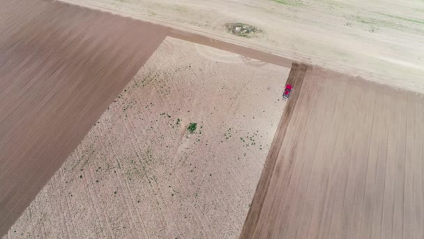 Вид с воздуха Трактор вспахивает землю, обрабатывая поле перед посевом, Весна — стоковое видео