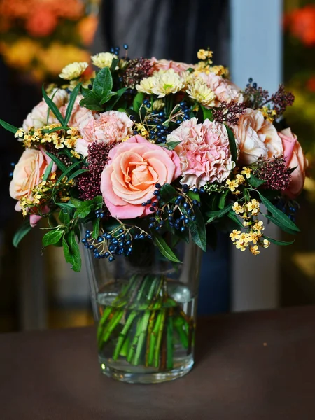 Strauß mit rosa Rosen und gelben Blumen in einer Glasvase — Stockfoto