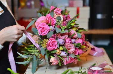 Kurdele gül buketi bağlayan kadın çiçekçi