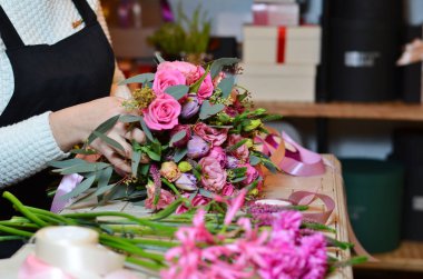 Kurdele gül buketi bağlayan kadın çiçekçi