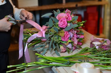 Kurdele gül buketi bağlayan kadın çiçekçi