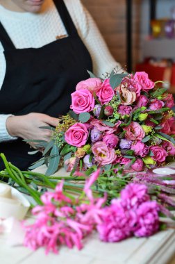 Kurdele gül buketi bağlayan kadın çiçekçi