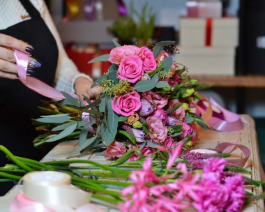 Kurdele gül buketi bağlayan kadın çiçekçi
