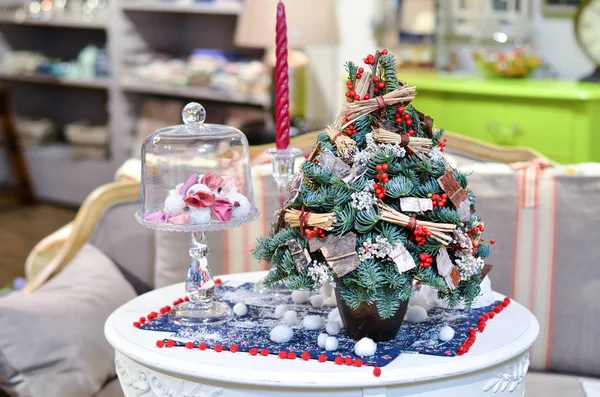 Küçük Noel ağaçları olan bir mum yanındaki masada