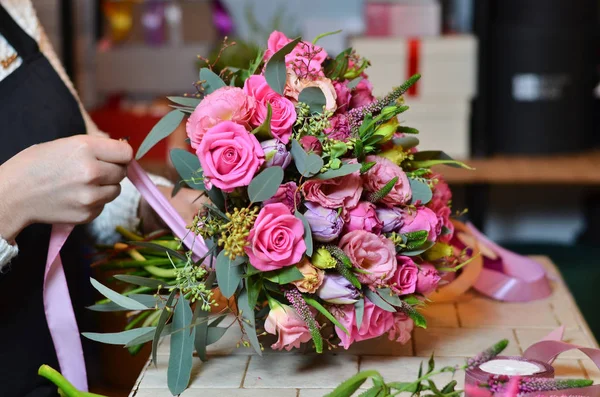 Kurdele gül buketi bağlayan kadın çiçekçi