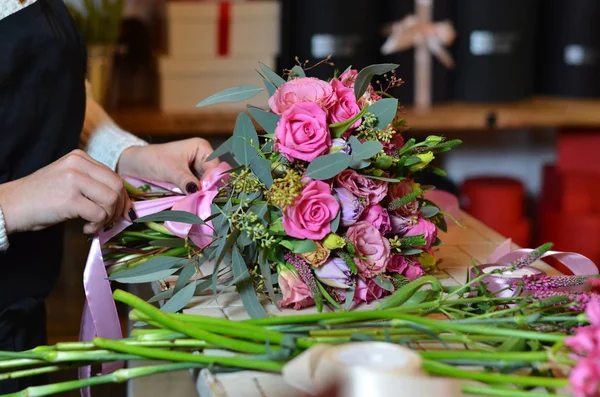 Blumenhändlerin bindet Schleife am Rosenstrauß — Stockfoto