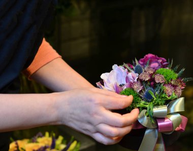 Küçük bir kutuda bir buket tutan bir kadın