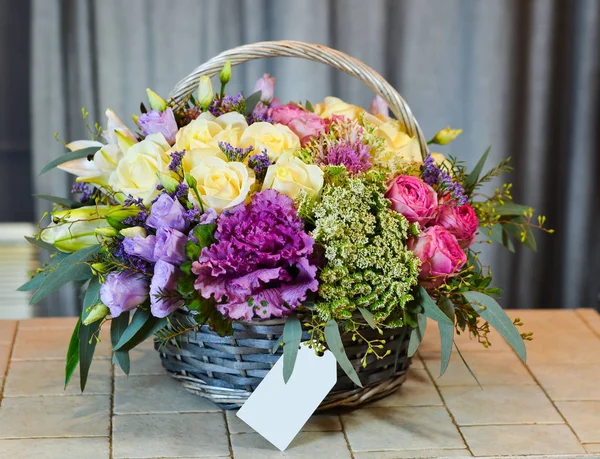 Boş gri etiketi ile gri bir sepet içinde gül buketi