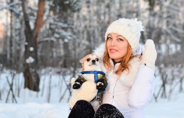 Kış orman karda bir köpek ile oturan kız