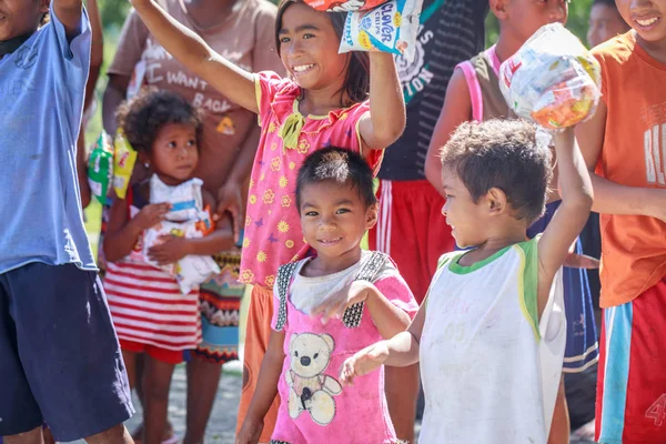 Filipino children standing in a line and holding snack in their — Stock Photo, Image