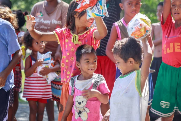 Bir sırada bekleyen ve holding Filipino çocuk snack onların 