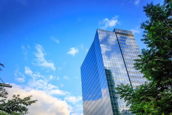 Modern cam binalar ve yeşil ile gökyüzü arka plan