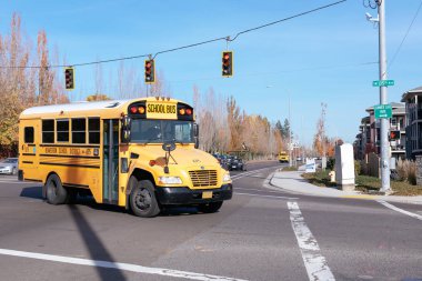 Kunduzkent, Oregon 'da sokak boyunca giden sarı okul otobüsü