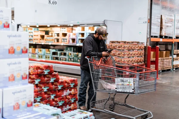 Люди с тележками в Оптовом магазине Костко. Costco - американская транснациональная корпорация, управляющая только цепочкой членства — стоковое фото