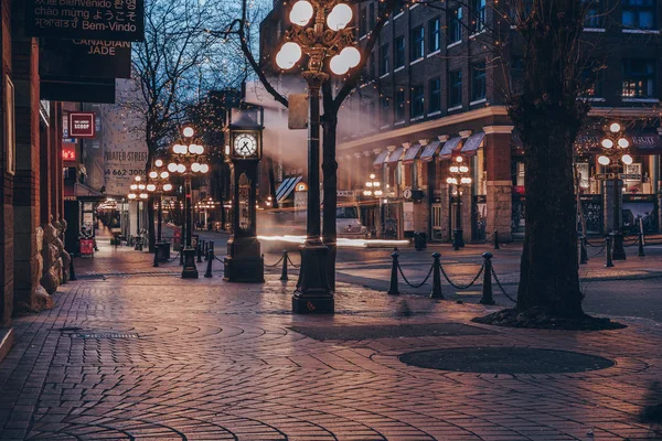 El famoso reloj de vapor en Gastown en la ciudad de Vancouver con coches senderos ligeros por la noche — Foto de Stock