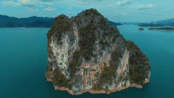 Aérea: Volando sobre la gran roca solitaria en el lago . — Vídeos de Stock