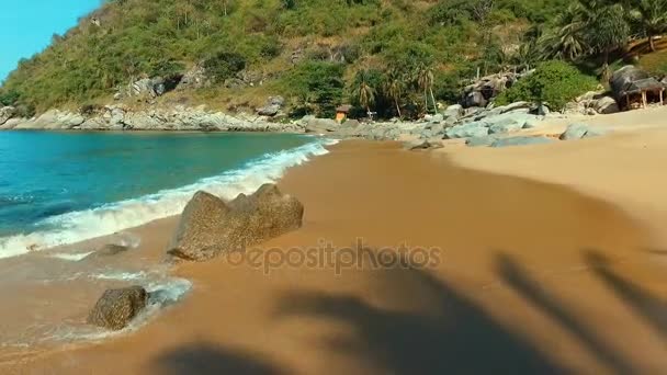 Aérea: Volando bajo sobre el agua y las olas en la playa salvaje . — Vídeos de Stock