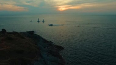 Hava: Promthep cape yakınında gün batımında tekne yelken. Phuket.