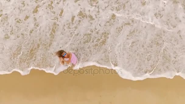 Antenne: Een meisje spinnen op het strand. — Stockvideo