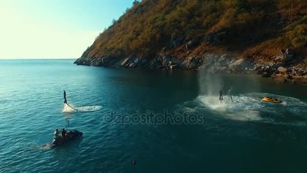 Aéreo: Voando em torno de dois homens em flyboard . — Vídeo de Stock