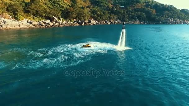 Aérea: Flyboarding cerca del barco al atardecer . — Vídeos de Stock