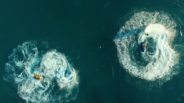 Aéreo: Dois homens em flyboard e dois jetski no mar . — Vídeo de Stock