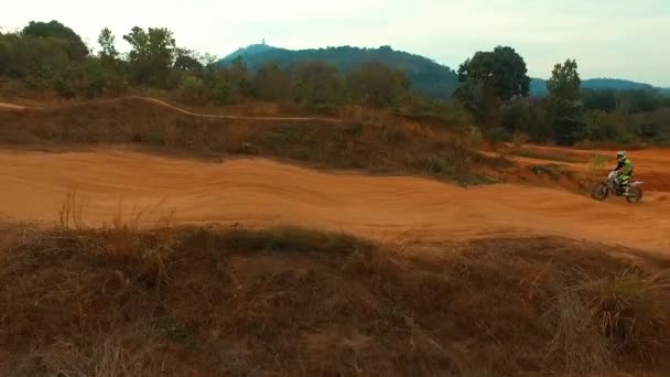 Aerial: Man riding a bike on motocross track. — Stock Video