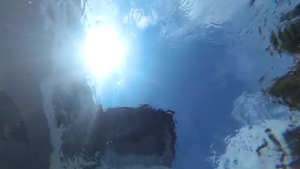 Círculos de agua y el brillo del sol desde el fondo de la piscina. Vista submarina . — Vídeo de stock