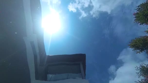 Pohled na oblohu s sluneční svit a domem ze dna bazénu. — Stock video