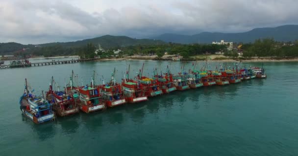 Aéreo: decolagem perto de barcos de pesca estão estacionados em uma linha . — Vídeo de Stock