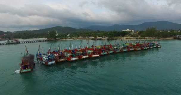 Aéreo: Barco de pesca está estacionando para os outros barcos no cais . — Vídeo de Stock