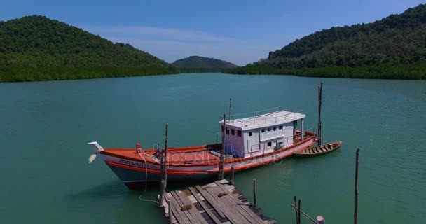 PHUKET, THAILAND January 30, 2017: Aerial: Thai boat is at the wooden pier in the bay. — Stock Video