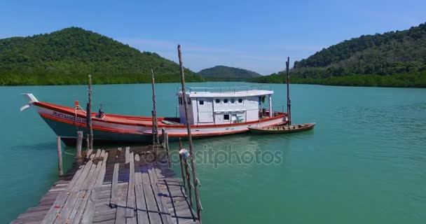 PHUKET, THAILAND January 30, 2017: Beautiful thai boat is at the wooden pier in the bay. — Stock Video