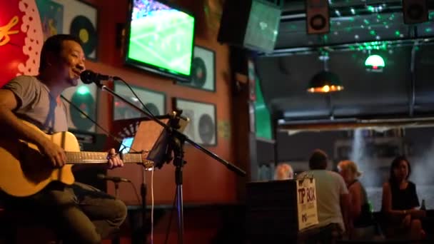 Bangkok, Thailand 20 April 2017: Man spelar gitarr och sjunger på scen i en bar. — Stockvideo