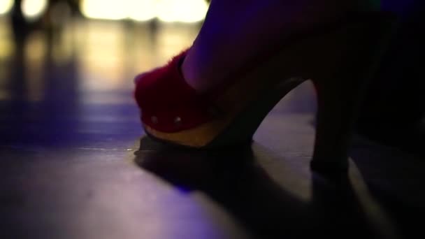 Nahaufnahme eines weiblichen Fußes in roten Stöckelschuhen in einem Nachtclub. — Stockvideo