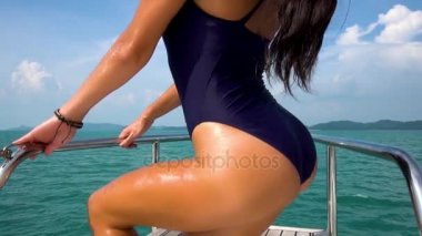 Güzel kız ağır çekimde yat yay üzerinde poz. Deniz Manzaralı.