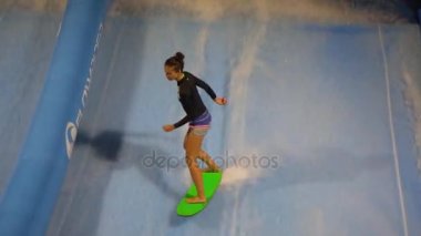 Phuket, Tayland 12 Mayıs 2017: Akış binici kız surf makine sörf yapıyor. Ağır çekim.