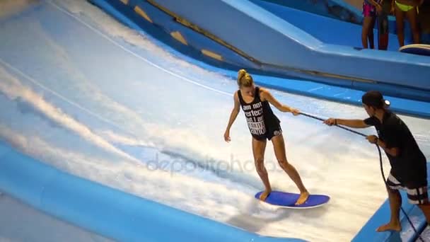 PHUKET, THAILAND May 12, 2017: A girl falls off the flowboard. Coach helps her. — Stock Video