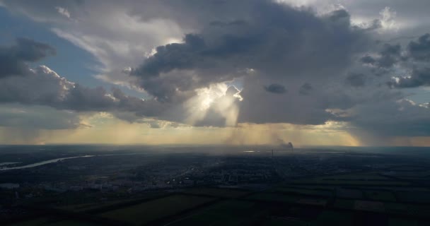 航空写真: 太陽の光は雲の切れ間から街に落ちる。その雨. — ストック動画