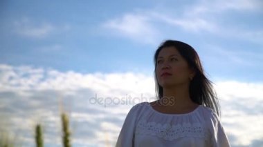 Kız bir buğday alanına yürüyor ve huzur içinde mesafe içine görünüyor.