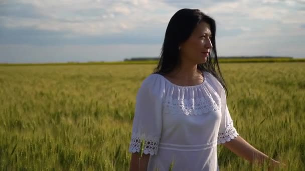 Gros plan d'une femme debout dans un champ de blé et admirant la beauté de la nature .
