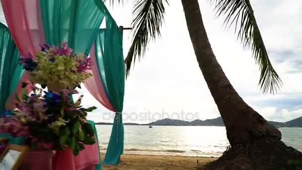 Prachtige bruiloft decoraties en boog op het strand onder de palmbomen. — Stockvideo