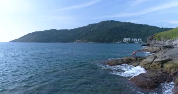 Aérea: Acro Yoga sobre las rocas en la playa cerca del mar . — Vídeos de Stock