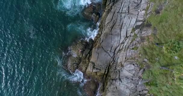 Воздушный: вид на море сверху со скалы и пара, делающая на ней акро-йога . — стоковое видео