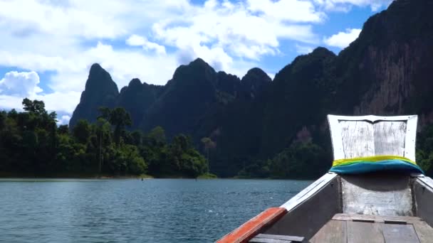 Longtail hajóval vitorlák, gyönyörű hegyek közt a tó mentén. Cheow lan. — Stock videók